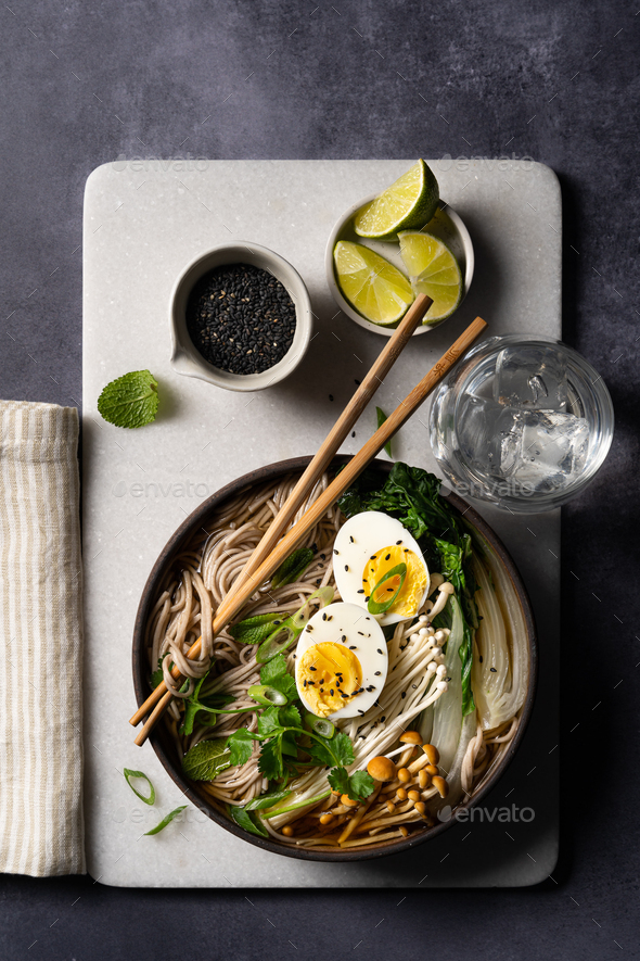 Top down view of Japanese soba noodle ramen soup on black background